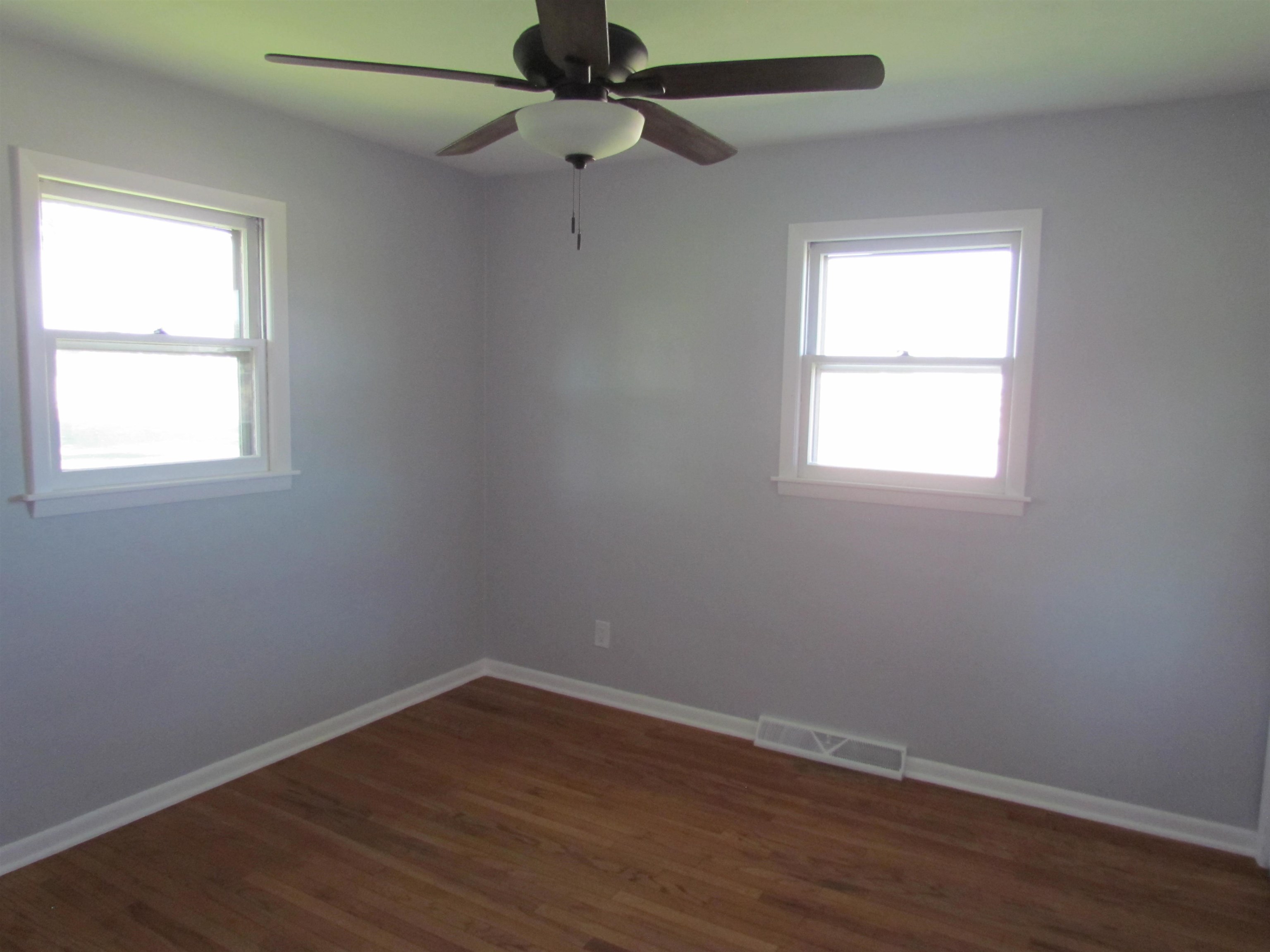 2475 North Pecatonica Road Pecatonica, IL 61063 - Photo 18 of 36 an empty room with wooden floor fan and windows