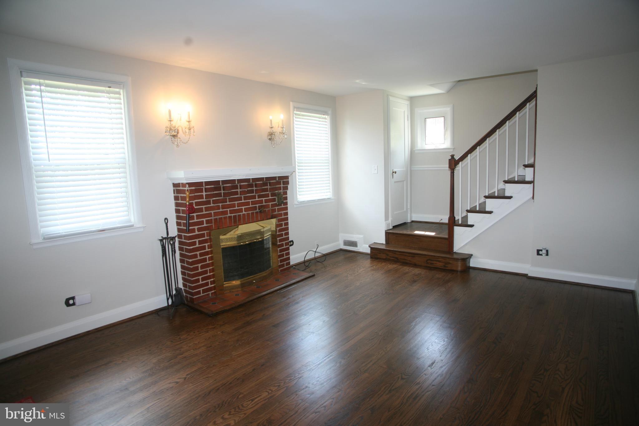 2 Dunmore Road Baltimore, MD 21228 - Photo 7 of 21 Living Room with brick fireplace & classic sconces