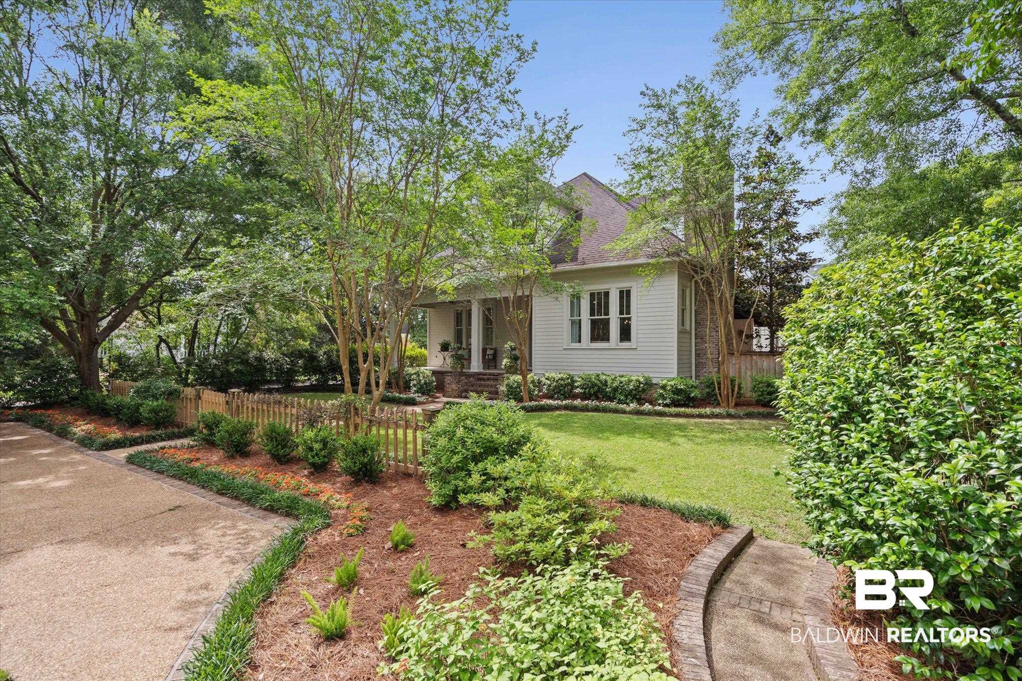 3813 Austill Lane Mobile, AL 36608 - Photo 33 of 37 White siding residence featuring a covered porch, multiple windows, a gabled roof, and a gravel driveway