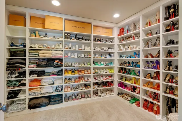 a view of walk in closet with clothes and shoes