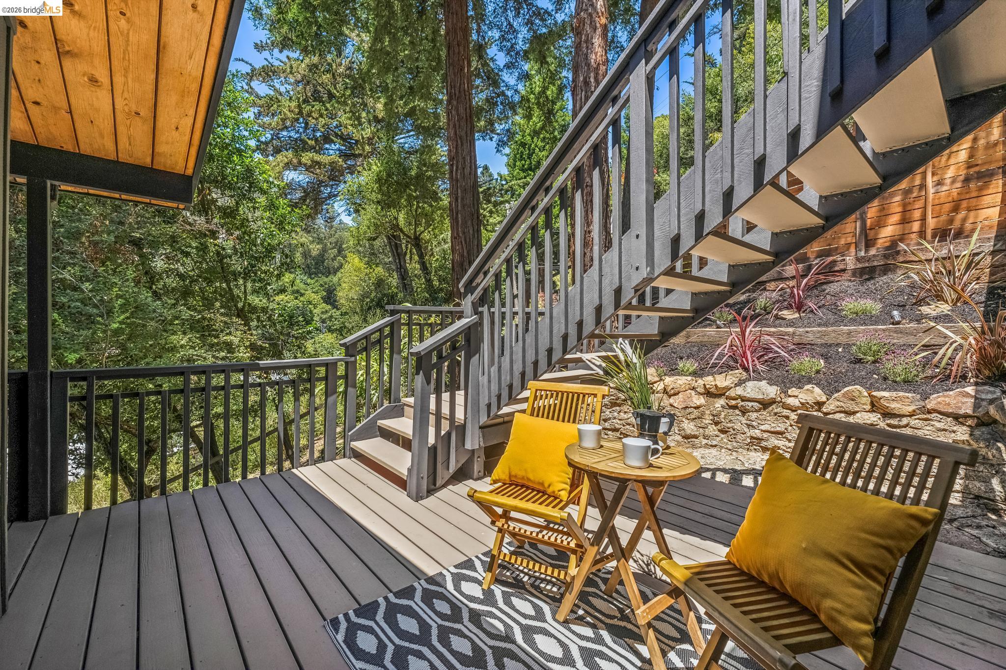 6645 Heather Ridge Way Oakland, CA 94611 - Photo 51 of 61 Spacious exterior deck with composite decking, dark wood railings, and a solid wood ceiling
