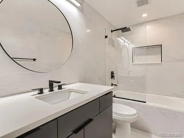 a bathroom with a sink a toilet and shower