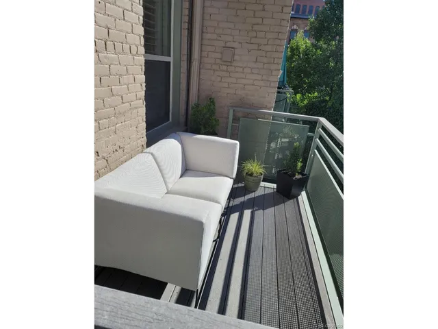 a roof deck view with couches and a potted plant on a table