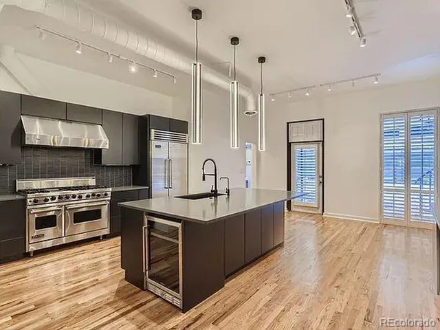 a kitchen with stainless steel appliances granite countertop a sink stove and wooden floor