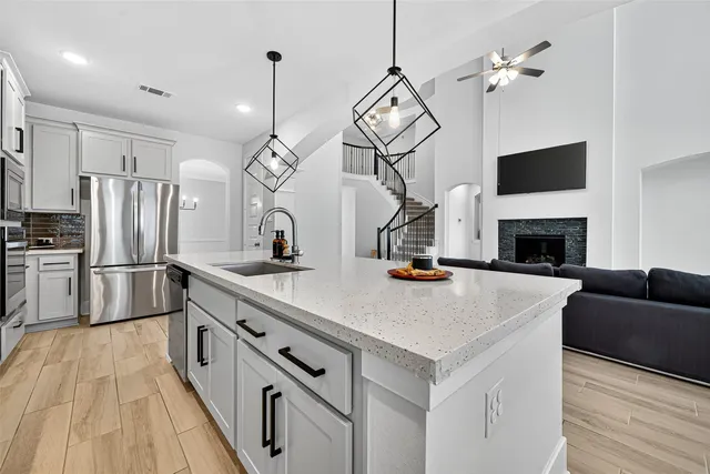 a kitchen with stainless steel appliances a stove refrigerator and a fireplace