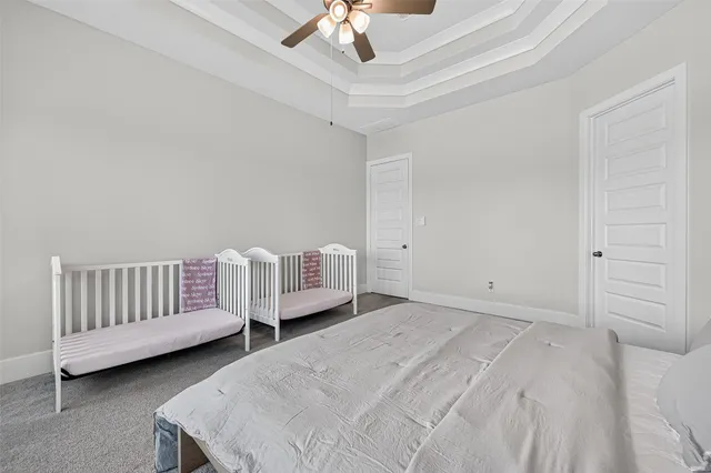 a spacious bedroom with a bed and a chandelier