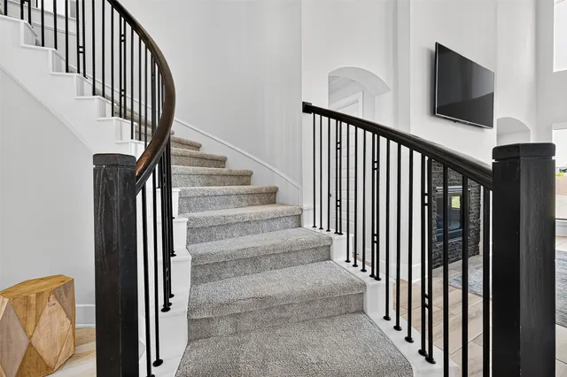 a view of staircase with lots of frames on wall and a window