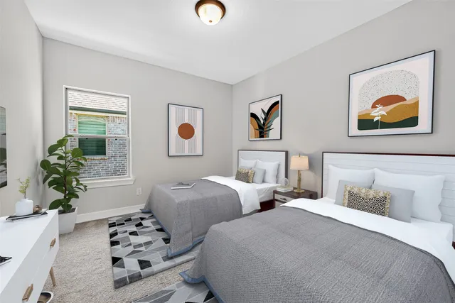 a bedroom with two beds and a potted plant