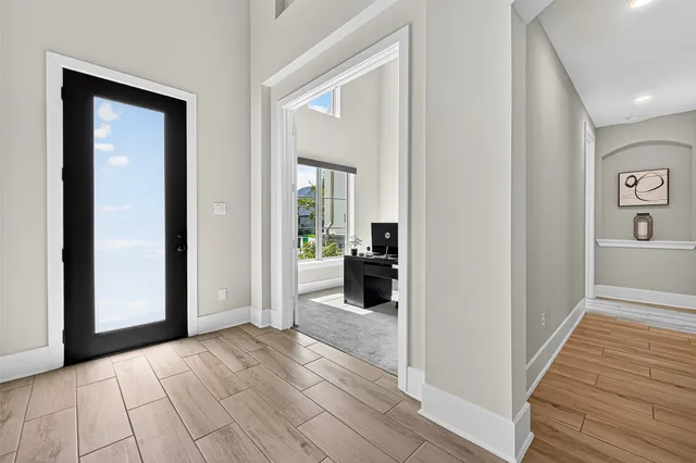 a view of a hallway view with wooden floor and a living room