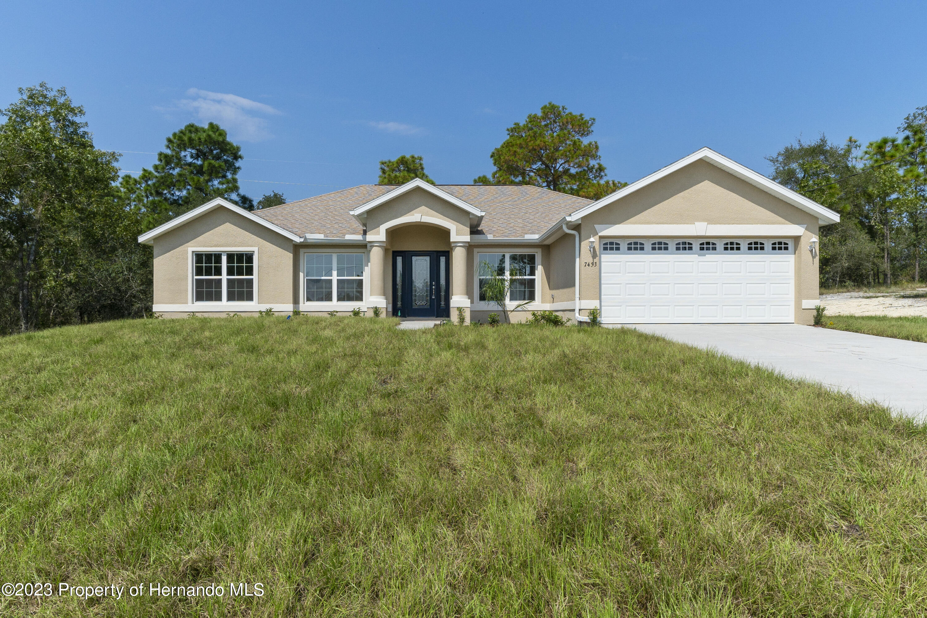 8433 Nightingale Road Weeki Wachee, FL 34613 - Photo 1 of 23 a view of a house with a yard and large tree