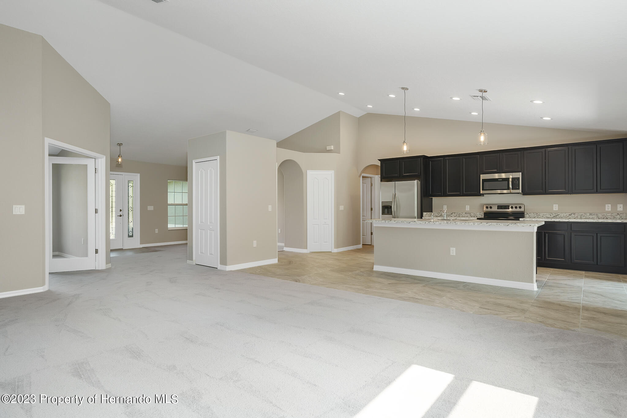 8433 Nightingale Road Weeki Wachee, FL 34613 - Photo 3 of 23 a view of kitchen with kitchen island a sink stainless steel appliances and cabinets