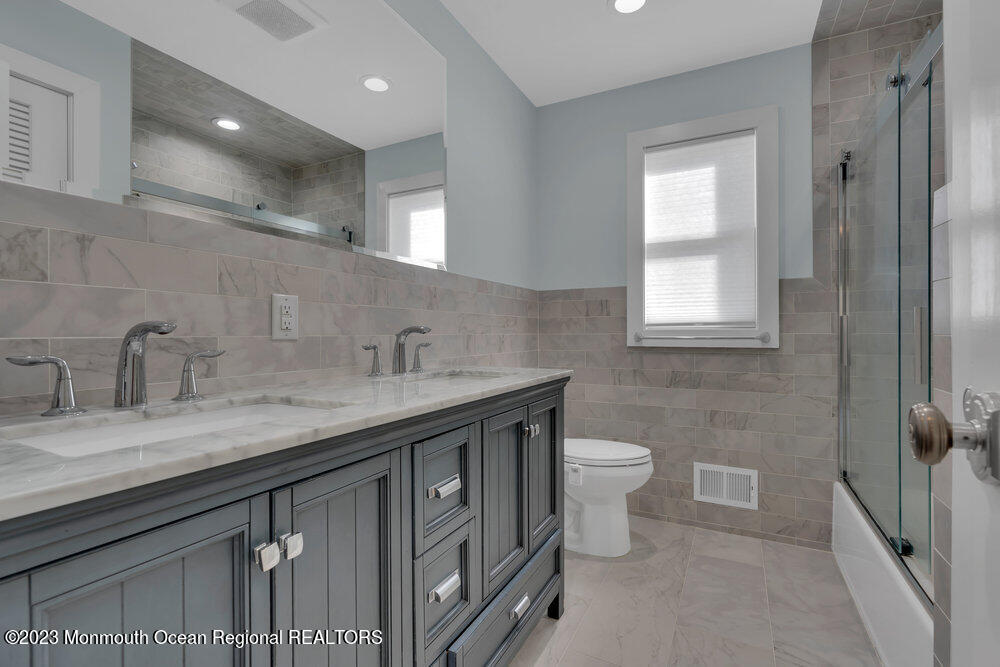 210 Richdale Road Colts Neck, NJ 07722 - Photo 20 of 40 a bathroom with a granite countertop sink a toilet and a mirror