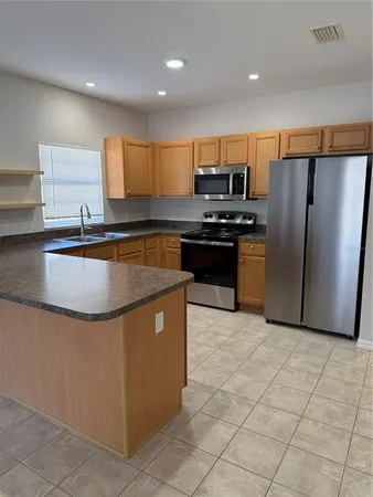 a kitchen with stainless steel appliances granite countertop a stove a refrigerator a sink and dishwasher