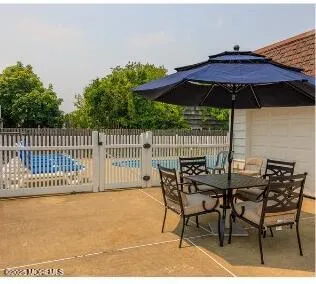 a view of chair and table with umbrella in the patio