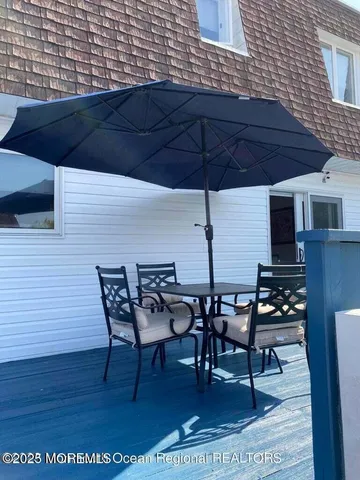 a view of a backyard with table and chairs under an umbrella
