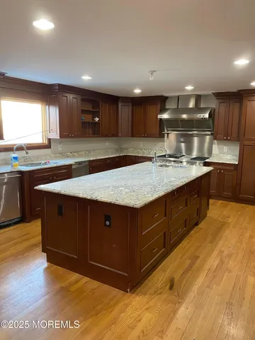 a kitchen with kitchen island granite countertop a sink window and cabinets
