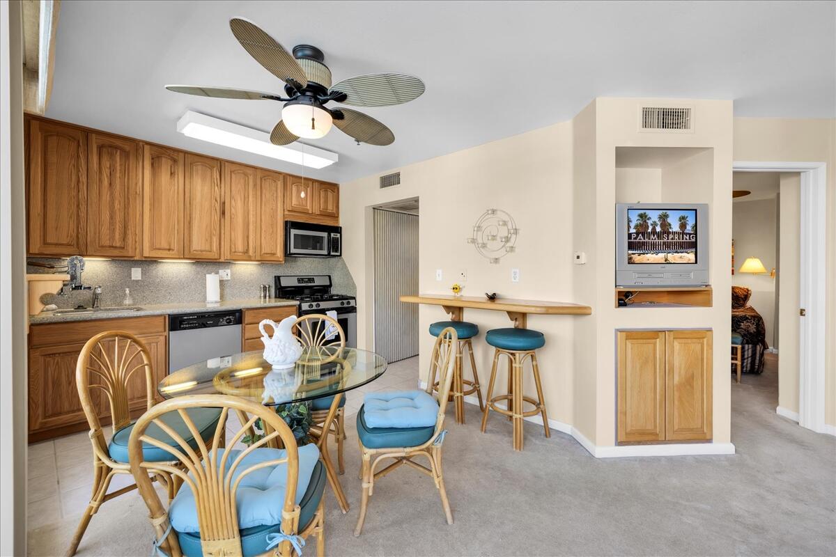 1555 North Chaparral Road, Unit 323 Palm Springs, CA 92262 - Photo 10 of 29 a view of a dining room with furniture a kitchen and chandelier