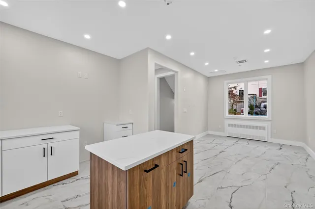 a view of an empty room with wooden floor and windows