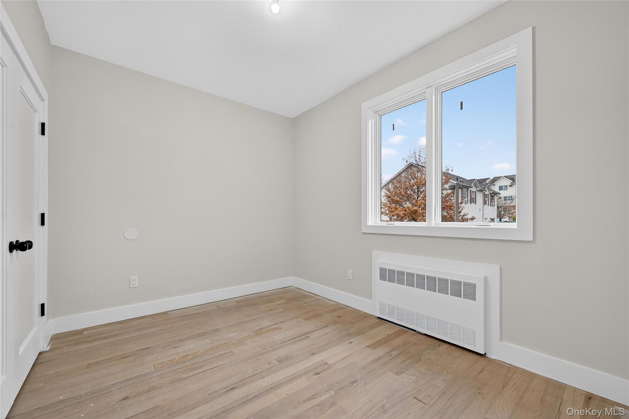 6 Milla Lane Spring Valley, NY 10977 - Photo 28 of 49 a view of an empty room with wooden floor and a window