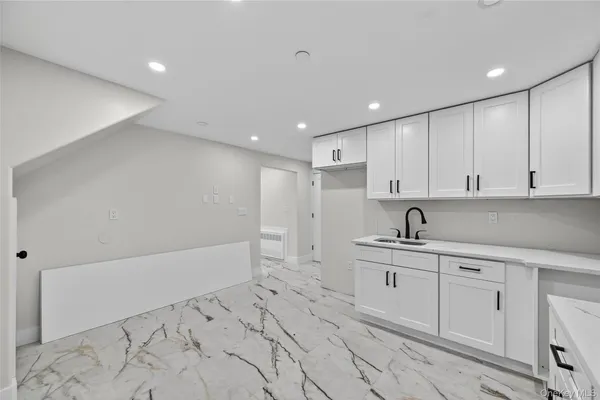 a kitchen with white cabinets appliances and sink