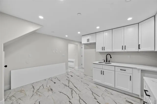 a kitchen with white cabinets appliances and sink