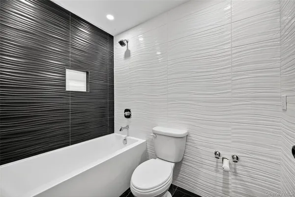 a bathroom with a granite countertop toilet and a sink