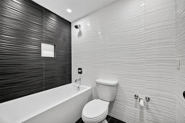 a bathroom with a granite countertop toilet and a sink