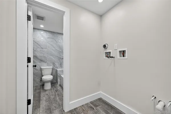a white toilet sitting next to a bath tub