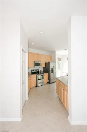 a open kitchen with white cabinets and stainless steel appliances