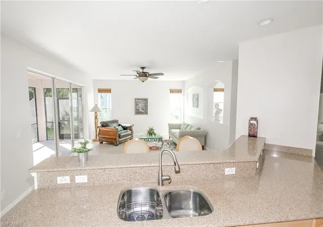 a kitchen with kitchen island a sink and a mirror