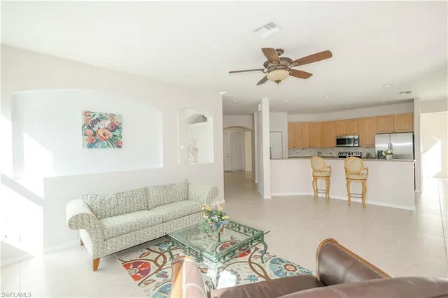 a living room with furniture and kitchen view