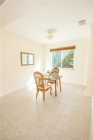 a dining room with furniture and a floor to ceiling window