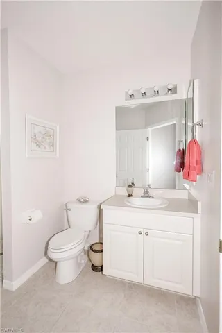 a bathroom with a sink vanity mirror and toilet