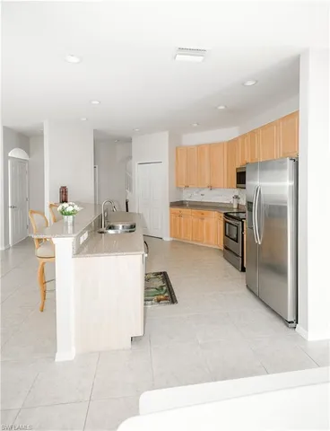a kitchen with a sink refrigerator and cabinets