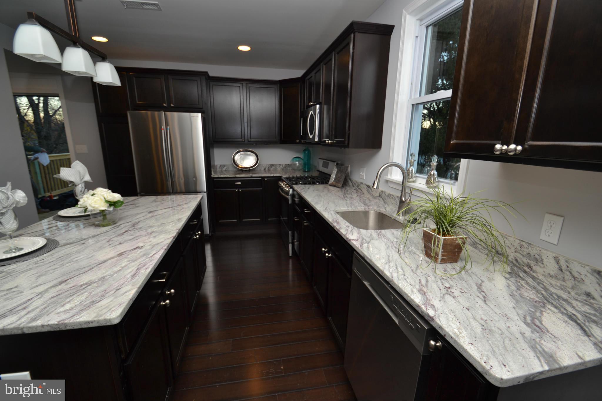 3810 Ridgecroft Road Baltimore, MD 21206 - Photo 11 of 30 a kitchen with granite countertop stainless steel appliances a sink stove refrigerator and cabinets