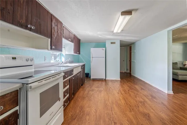 a kitchen with stainless steel appliances granite countertop a wooden cabinets and a stove top oven