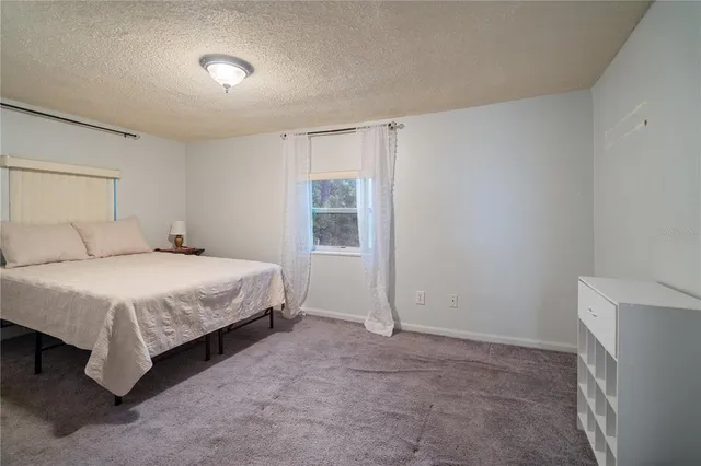 a spacious bedroom with a bed and a cabinets
