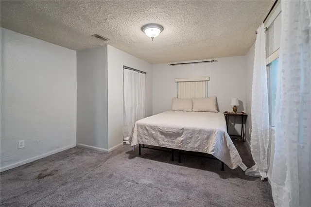 a spacious bedroom with a bed and a night stand