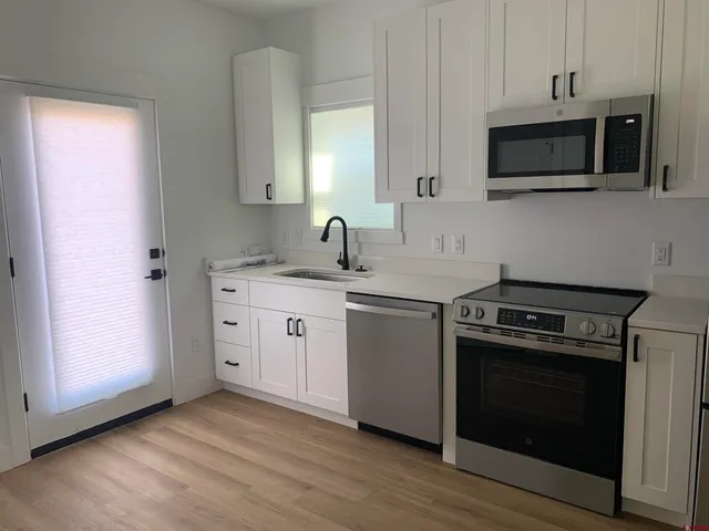 a kitchen with stainless steel appliances a stove a sink and a microwave