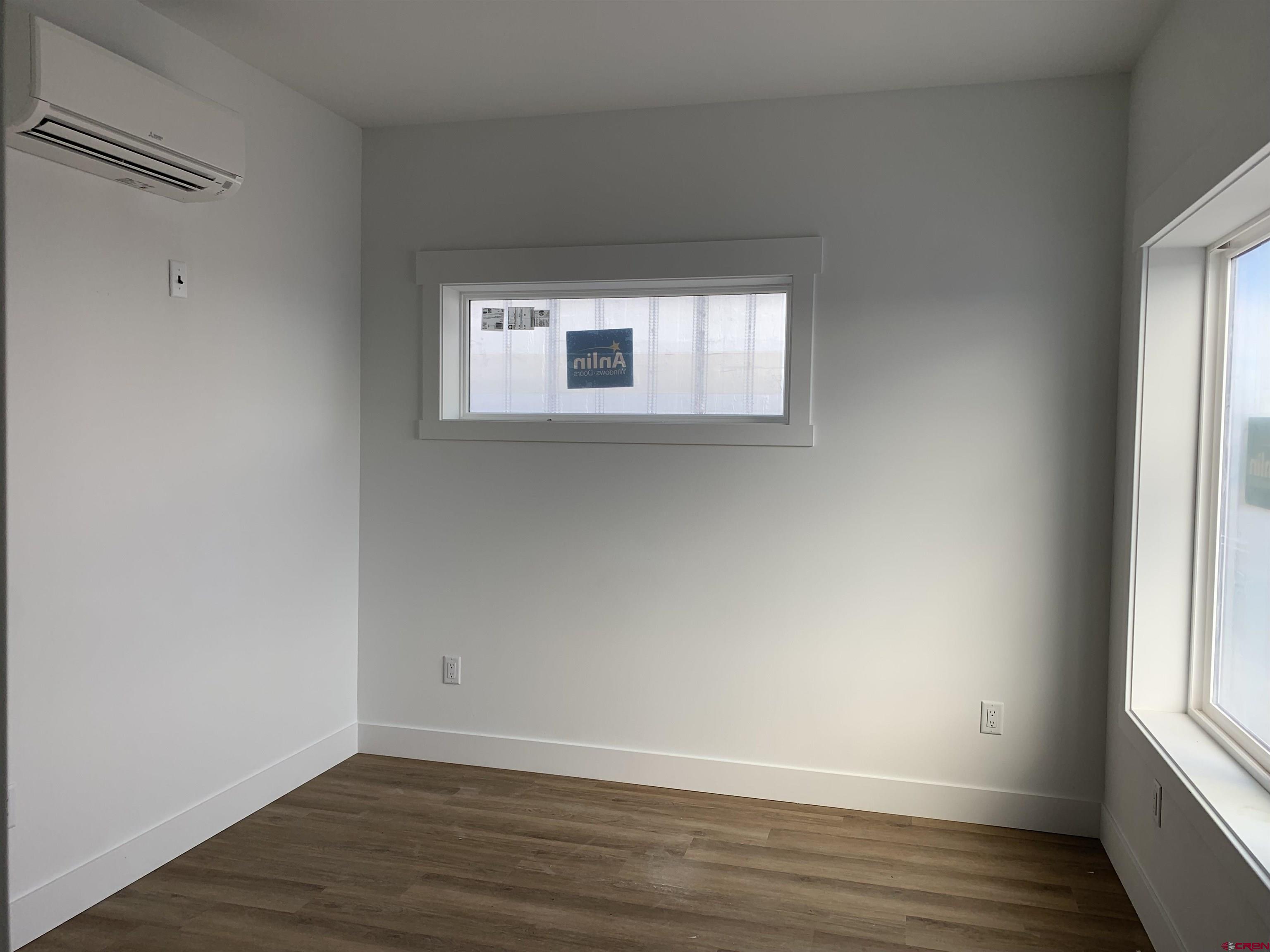 210 Manzano Circle Ignacio, CO 81137 - Photo 7 of 9 an empty room with wooden floor and windows