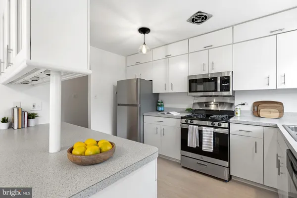 a kitchen with stainless steel appliances a stove microwave and refrigerator