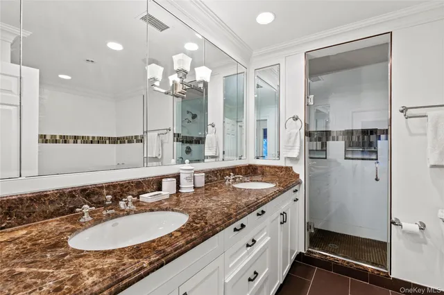 a bathroom with a granite countertop double vanity sink and mirror