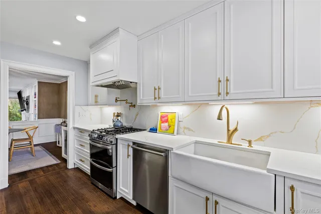 a kitchen with granite countertop a sink a stove and cabinets