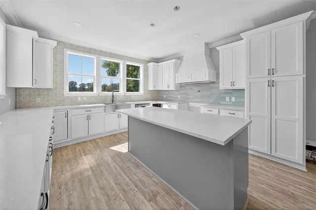a kitchen with a sink white cabinets and white appliances