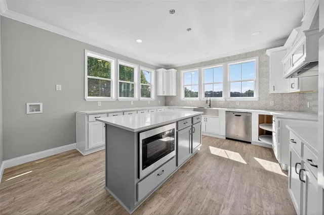a kitchen with stainless steel appliances granite countertop a stove a sink and a microwave