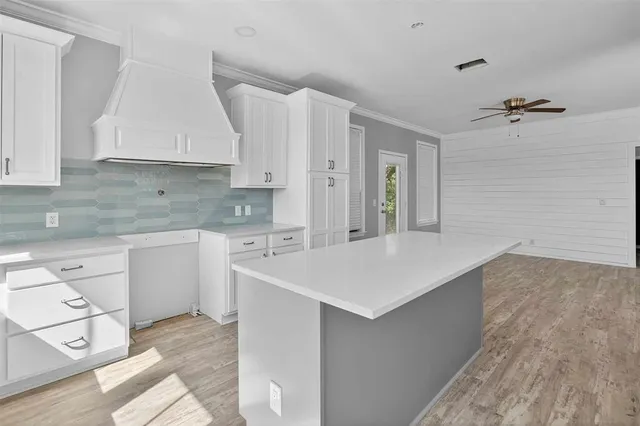 a kitchen that has a sink a stove and cabinets
