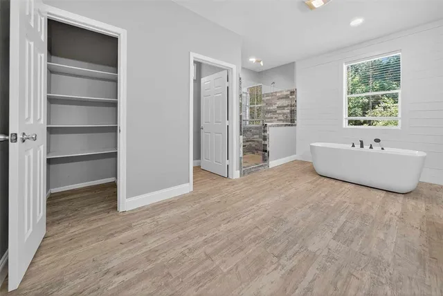 a white bath tub sitting in a bathroom next to a window