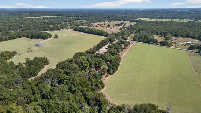 an aerial view of ocean and residential houses with outdoor space