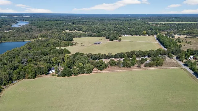an aerial view of a house with a yard and a lake view