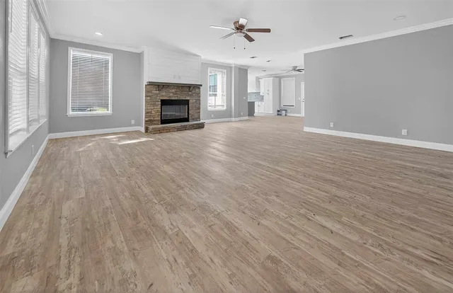 wooden floor fireplace and windows in an empty room